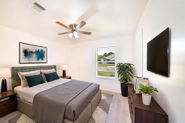 a bedroom with a large bed and a chandelier