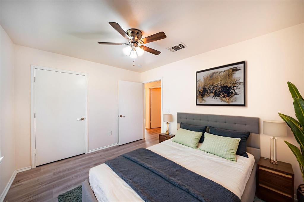 714 East 12th Street Bonham, TX 75418 - Photo 7 of 18 a bedroom with a large bed and a chandelier