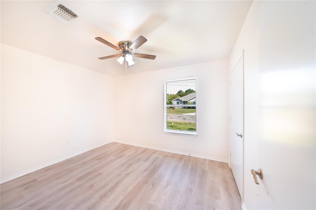 714 East 12th Street Bonham, TX 75418 - Photo 10 of 18 an empty room with a window and a ceiling fan