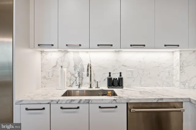 a living room with furniture a flat screen tv and kitchen view