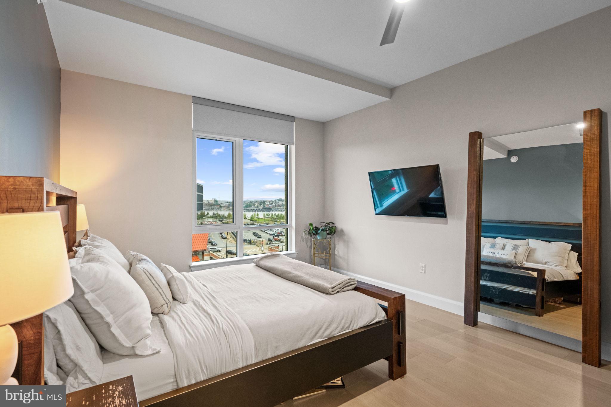 1330 Lancaster Street, Unit C603 Baltimore, MD 21231 - Photo 26 of 63 a bedroom with a bed and a flat tv screen on the dresser