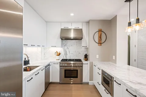 a kitchen with granite countertop white cabinets and a sink