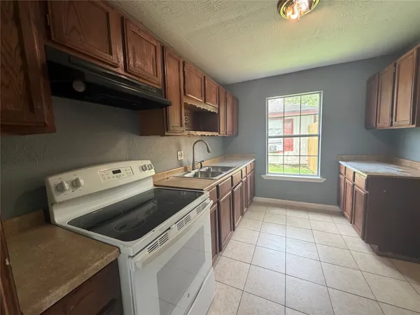 a kitchen with a stove a microwave and cabinets