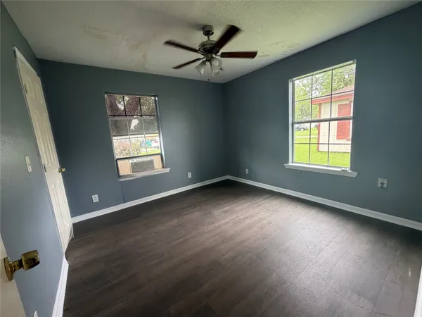 a view of a livingroom with a window and wooden floor