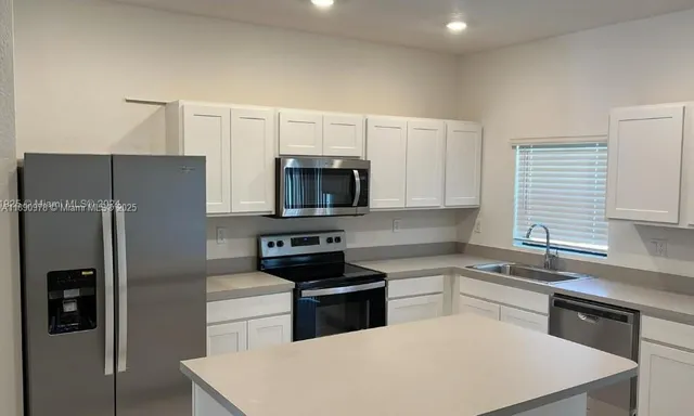 a kitchen with cabinets and stainless steel appliances