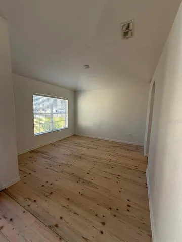 a view of an empty room with a chandelier fan