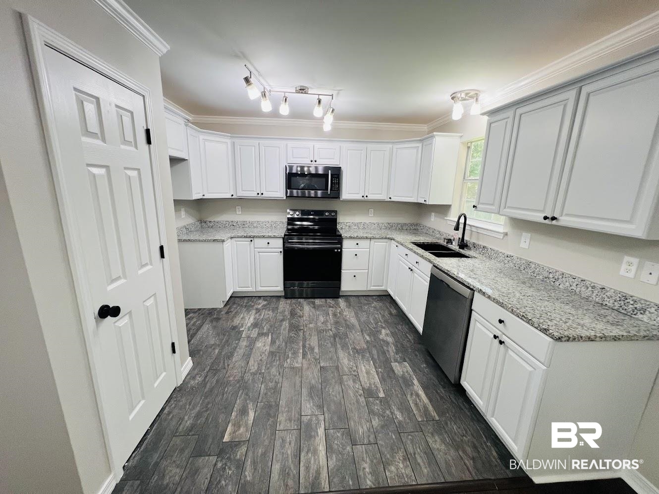 266 Ridgewood Drive Daphne, AL 36526 - Photo 8 of 34 Kitchen featuring white cabinetry, granite countertops, black appliances, a black sink with a matte black faucet, and wood-finish flooring