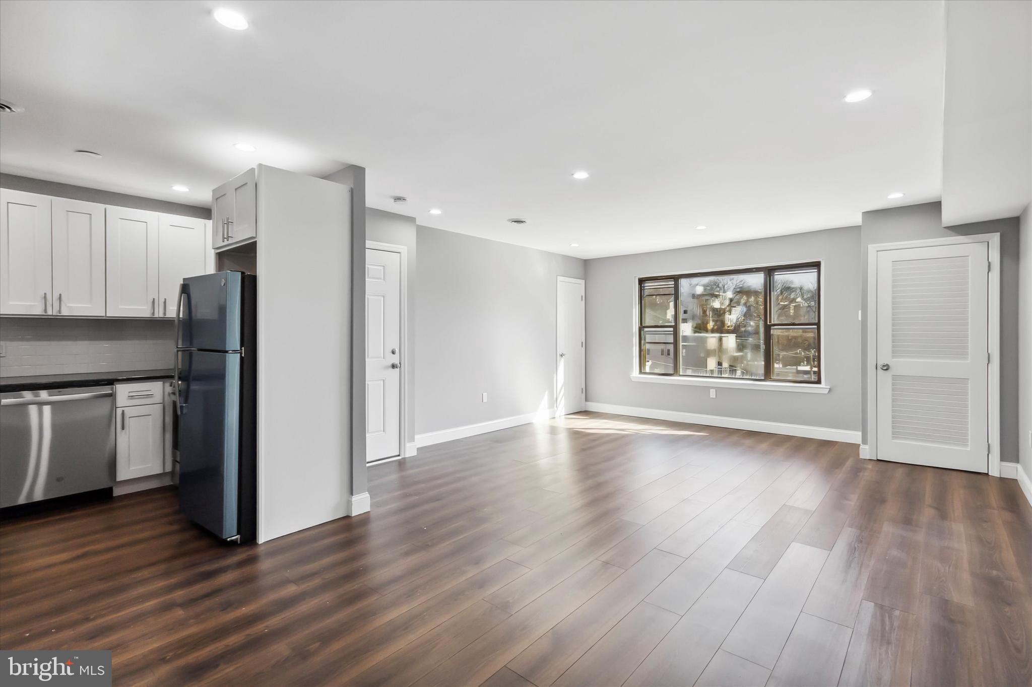 296 Greenough Street, Unit 2 Philadelphia, PA 19127 - Photo 4 of 24 a view of an empty room with a window and wooden floor