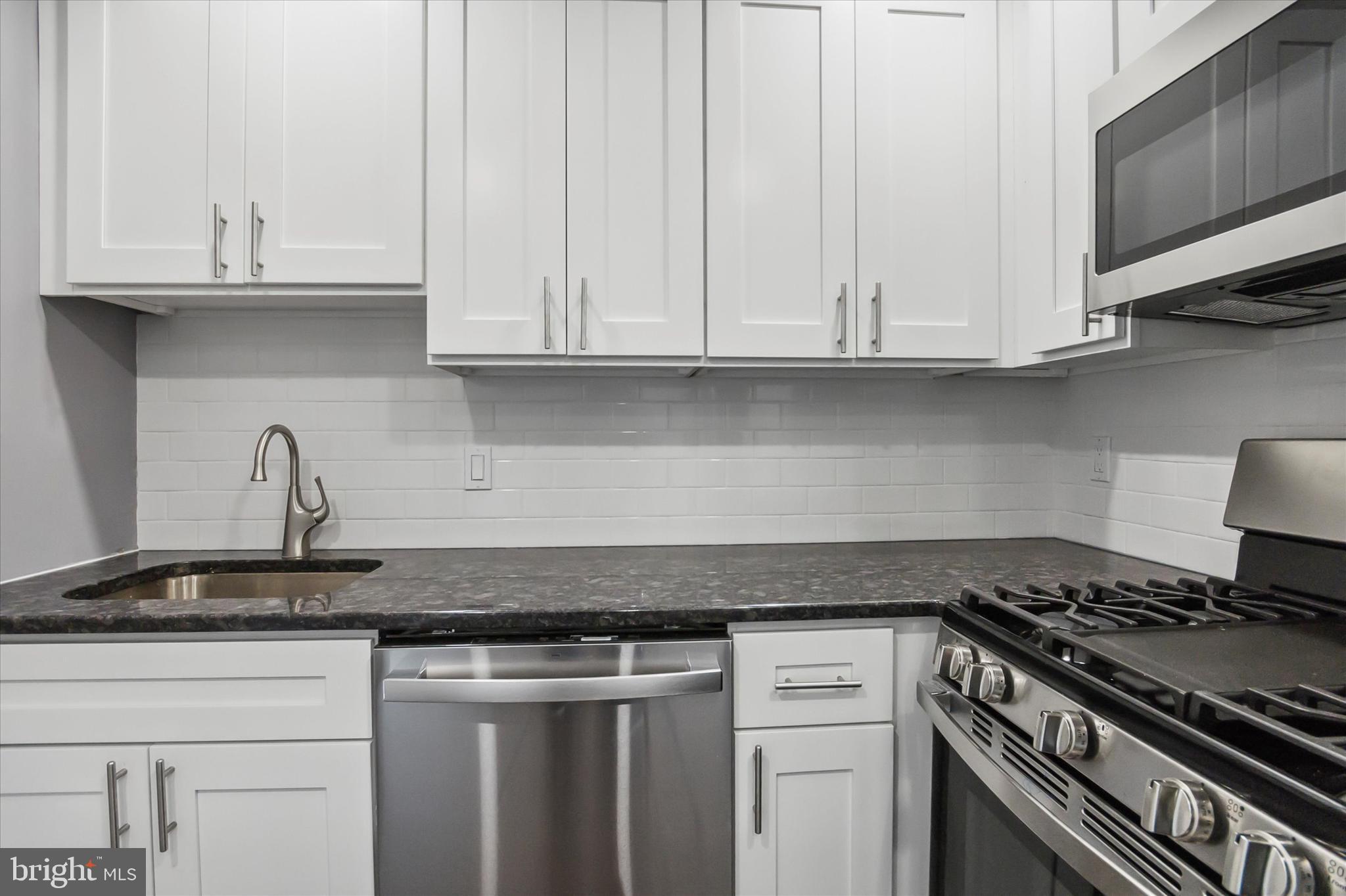 296 Greenough Street, Unit 2 Philadelphia, PA 19127 - Photo 10 of 24 a kitchen with granite countertop white cabinets and a stove