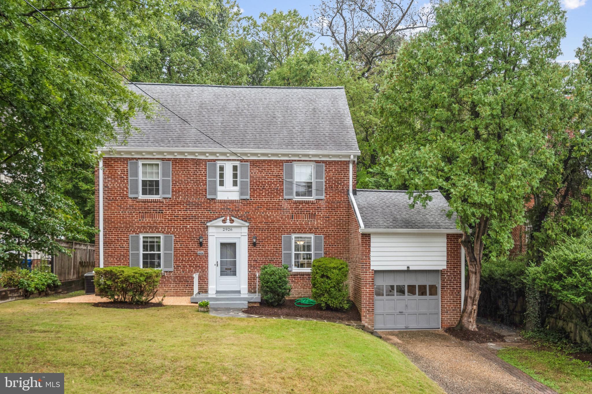 2926 Kanawha Street Northwest Washington, DC 20015 - Photo 1 of 34 a front view of a house with a yard and garage
