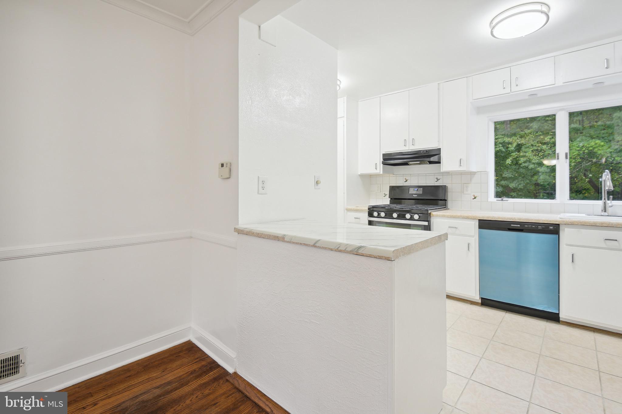 2926 Kanawha Street Northwest Washington, DC 20015 - Photo 12 of 34 a kitchen with granite countertop a stove a sink and a microwave