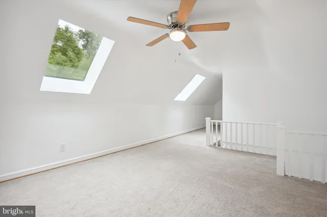 an empty room with a ceiling fan and window