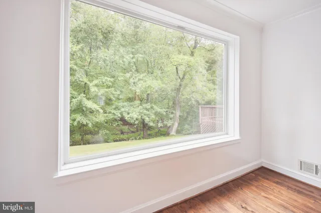 an empty room with wooden floor and a window