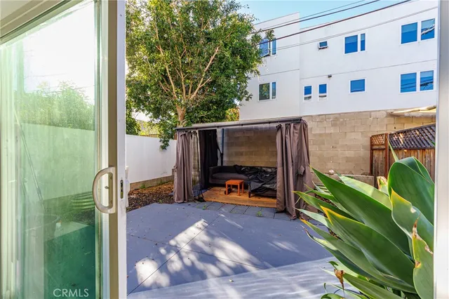 a view of a backyard with furniture and floor to ceiling window