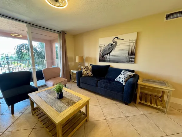 a living room with furniture a flat screen tv and a floor to ceiling window