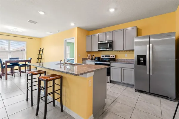 a kitchen with stainless steel appliances granite countertop a stove a sink a microwave and a refrigerator