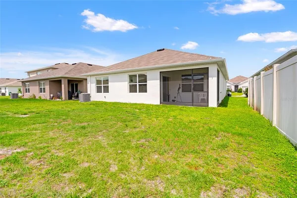 a view of a house with a big yard and large trees