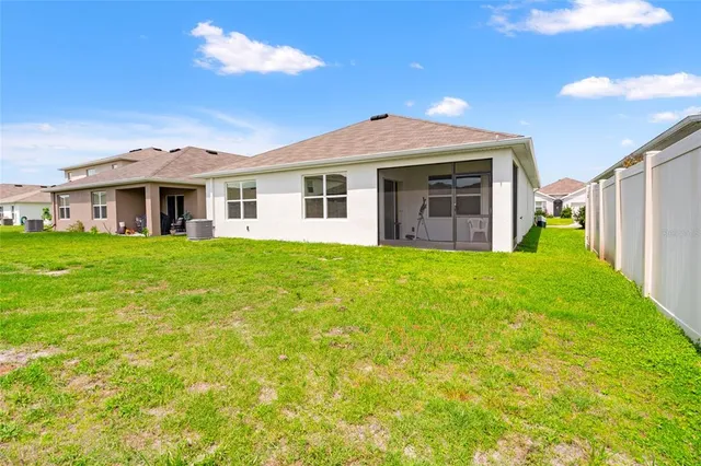 a view of a house with a big yard and large trees