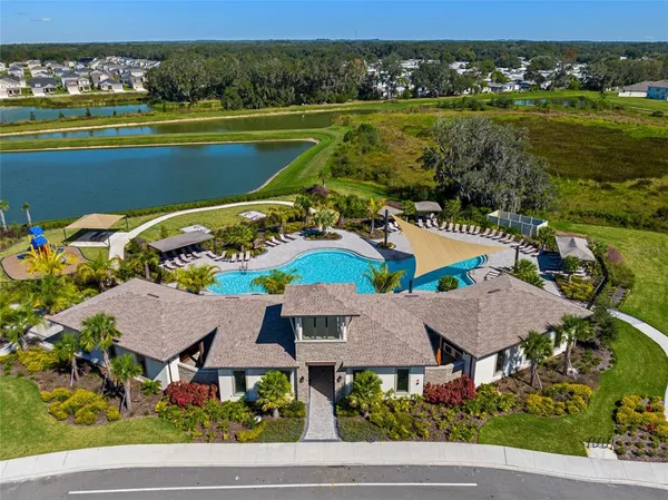 an aerial view of residential houses with outdoor space and lake view