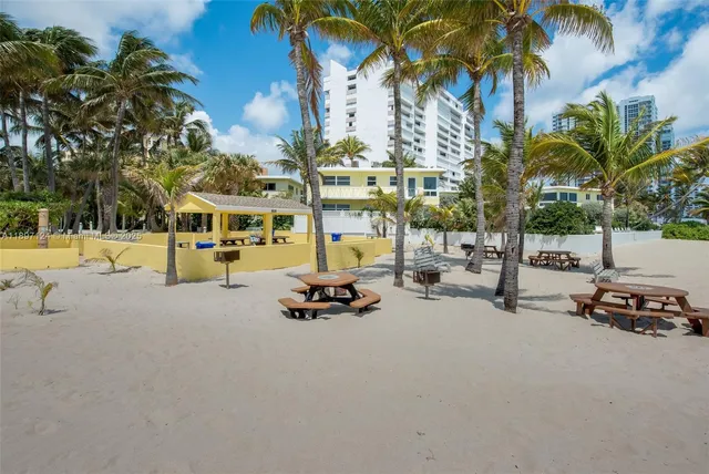 a view of a swimming pool with a lawn chairs under palm trees