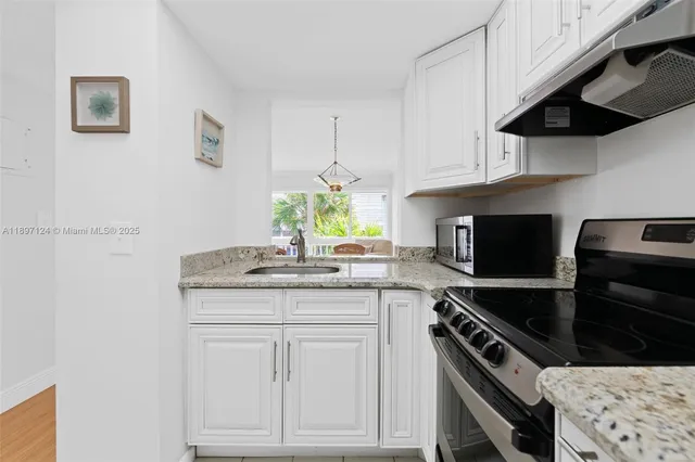 a kitchen with granite countertop a stove and a sink