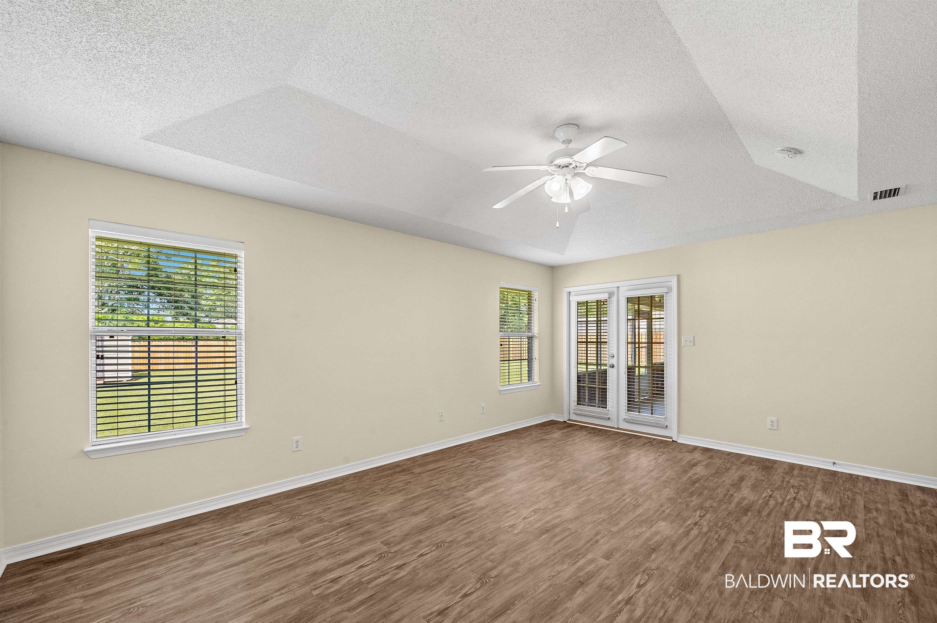 12443 Venice Boulevard Foley, AL 36535 - Photo 41 of 59 Spare room with a tray ceiling, wood-type flooring, ceiling fan, and a wealth of natural light