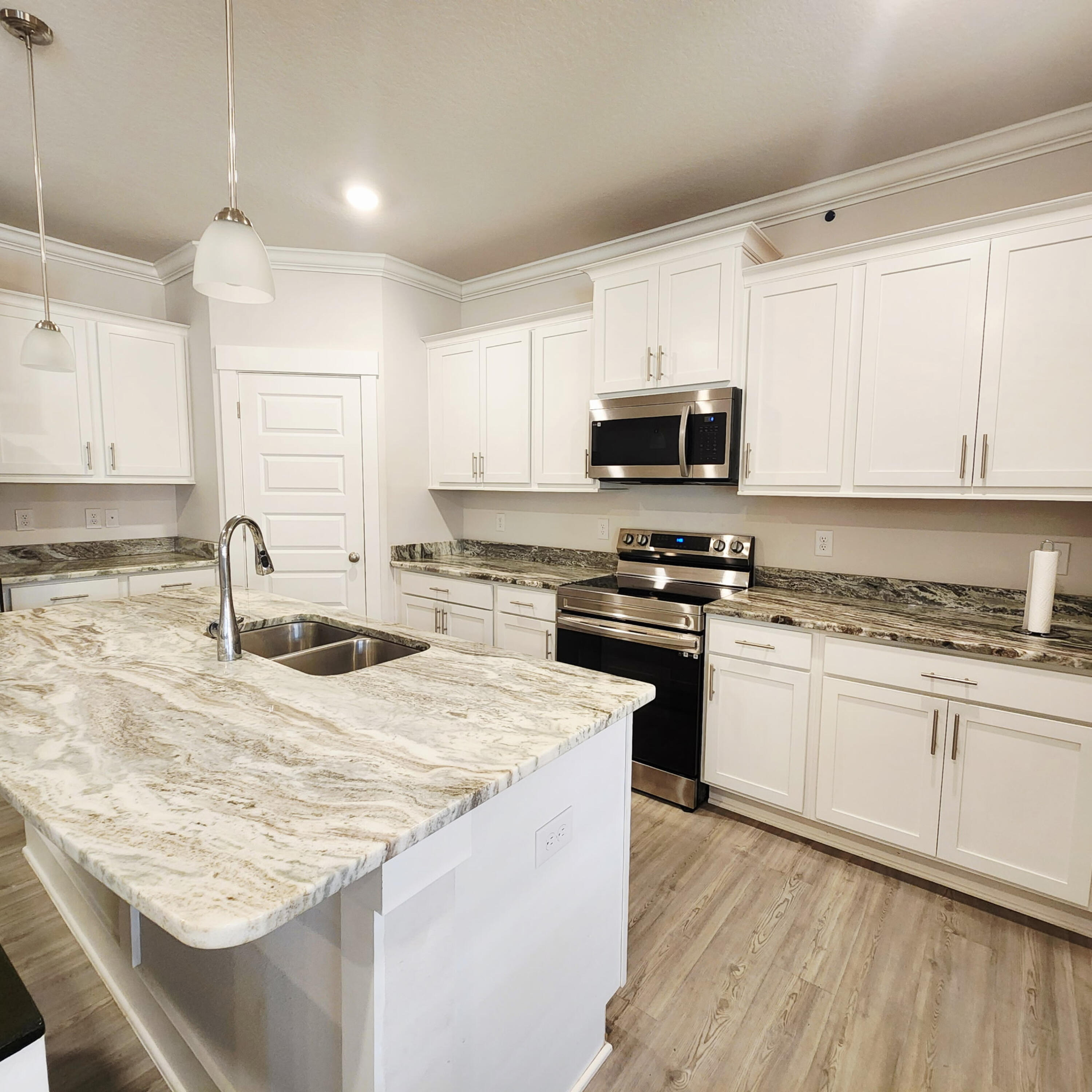 1927 Appleton Drive Cantonment, FL 32533 - Photo 2 of 8 a kitchen with granite countertop a sink stove and microwave with wooden floor