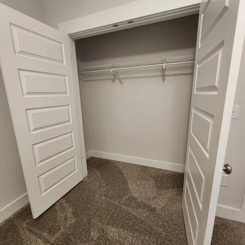 a view of walk in closet with empty racks