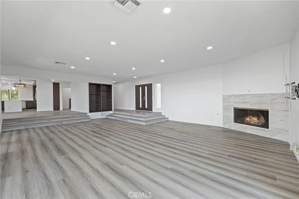 a view of a room with kitchen wooden floor and windows