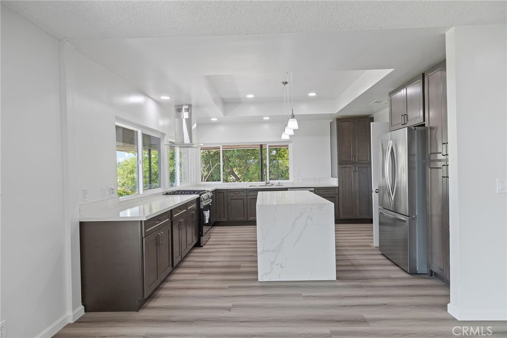 1281 Mayapan Road La Habra Heights, CA 90631 - Photo 18 of 65 a kitchen with stainless steel appliances granite countertop a refrigerator a sink dishwasher a stove and white countertops with wooden floor
