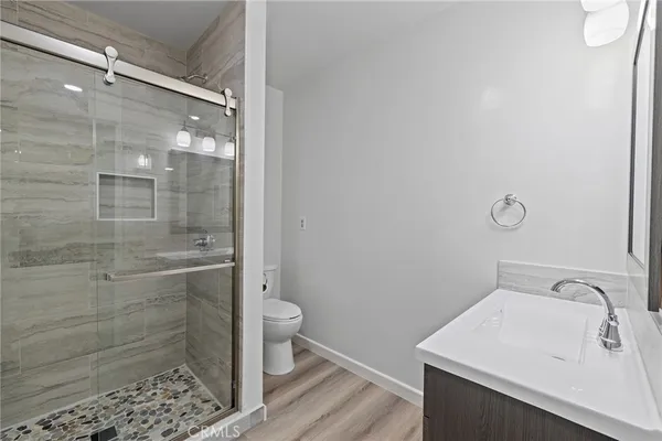 an empty room with wooden floor ceiling fan and windows