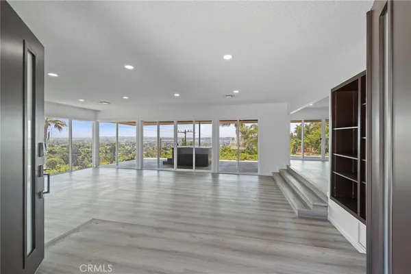 a view of empty room with wooden floor and fireplace