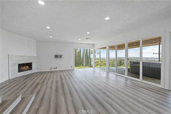 a view of a livingroom with wooden floor and a fireplace