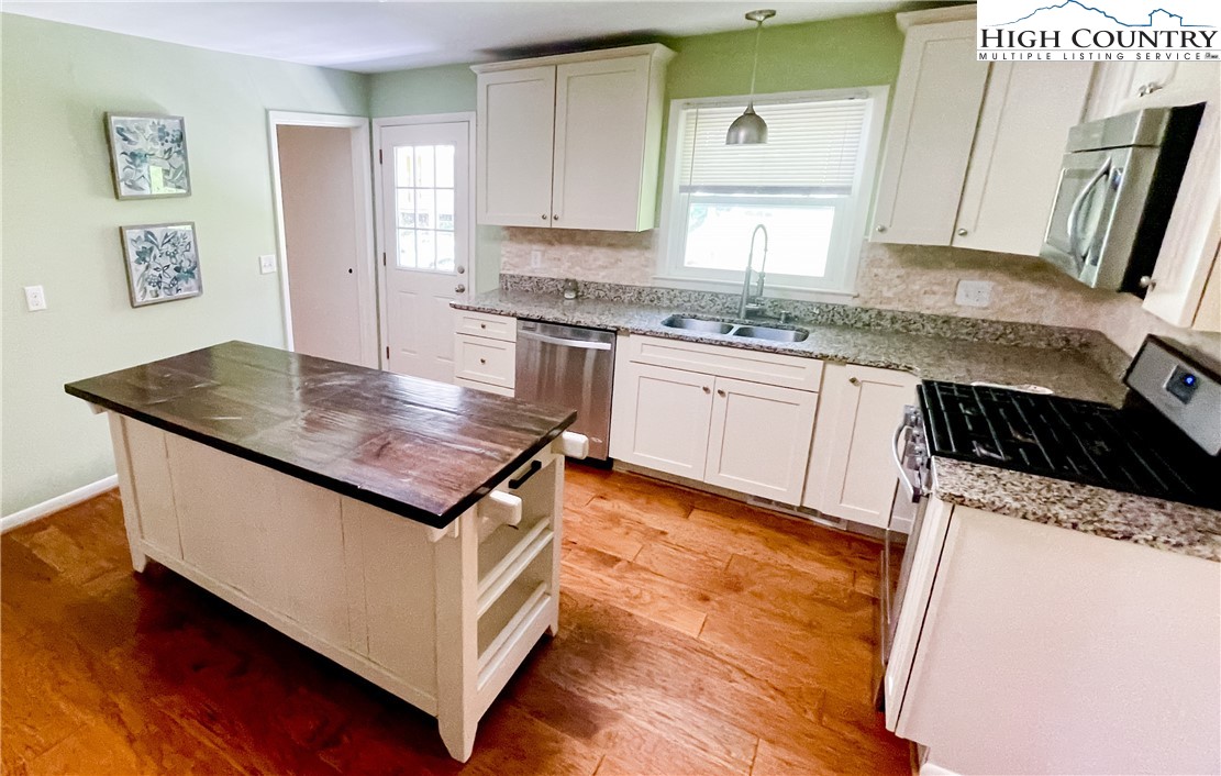 153 Wey Street Boone, NC 28607 - Photo 17 of 41 a kitchen with granite countertop a sink a stove top oven a counter space and cabinets