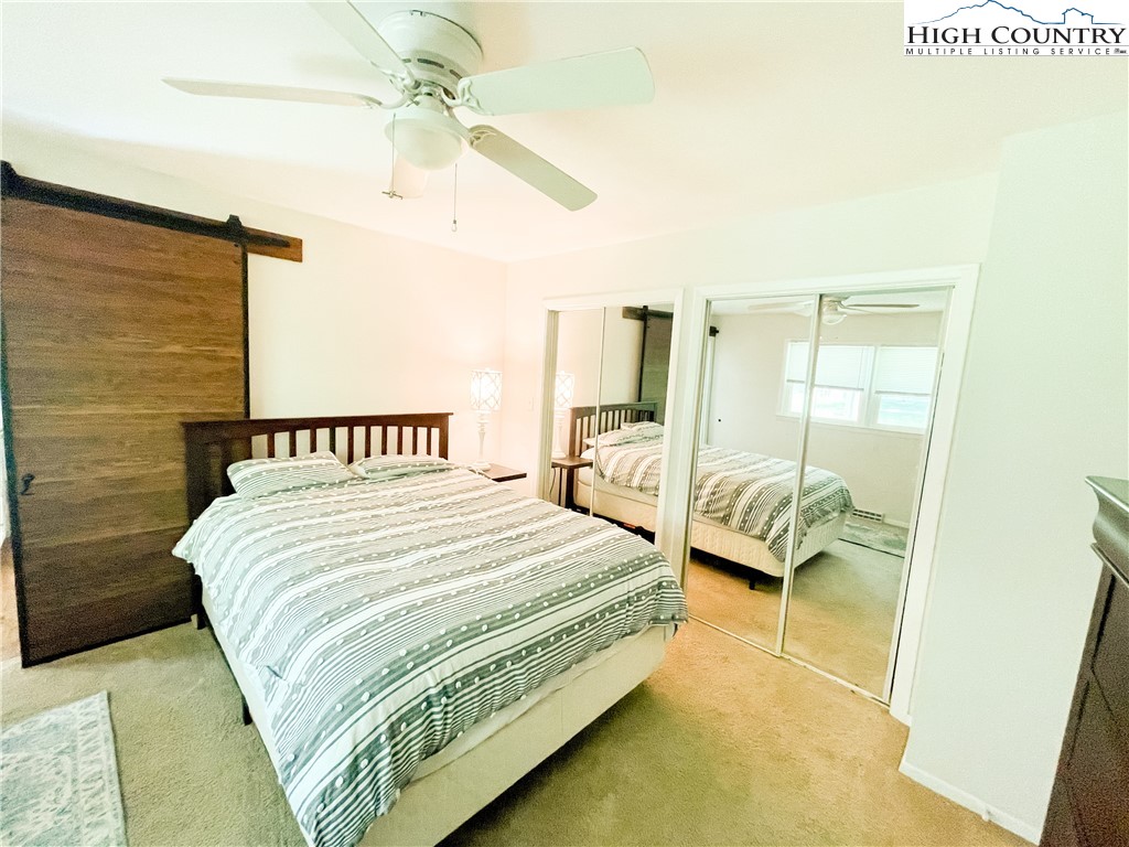 153 Wey Street Boone, NC 28607 - Photo 18 of 41 a bedroom with a bed and a chandelier