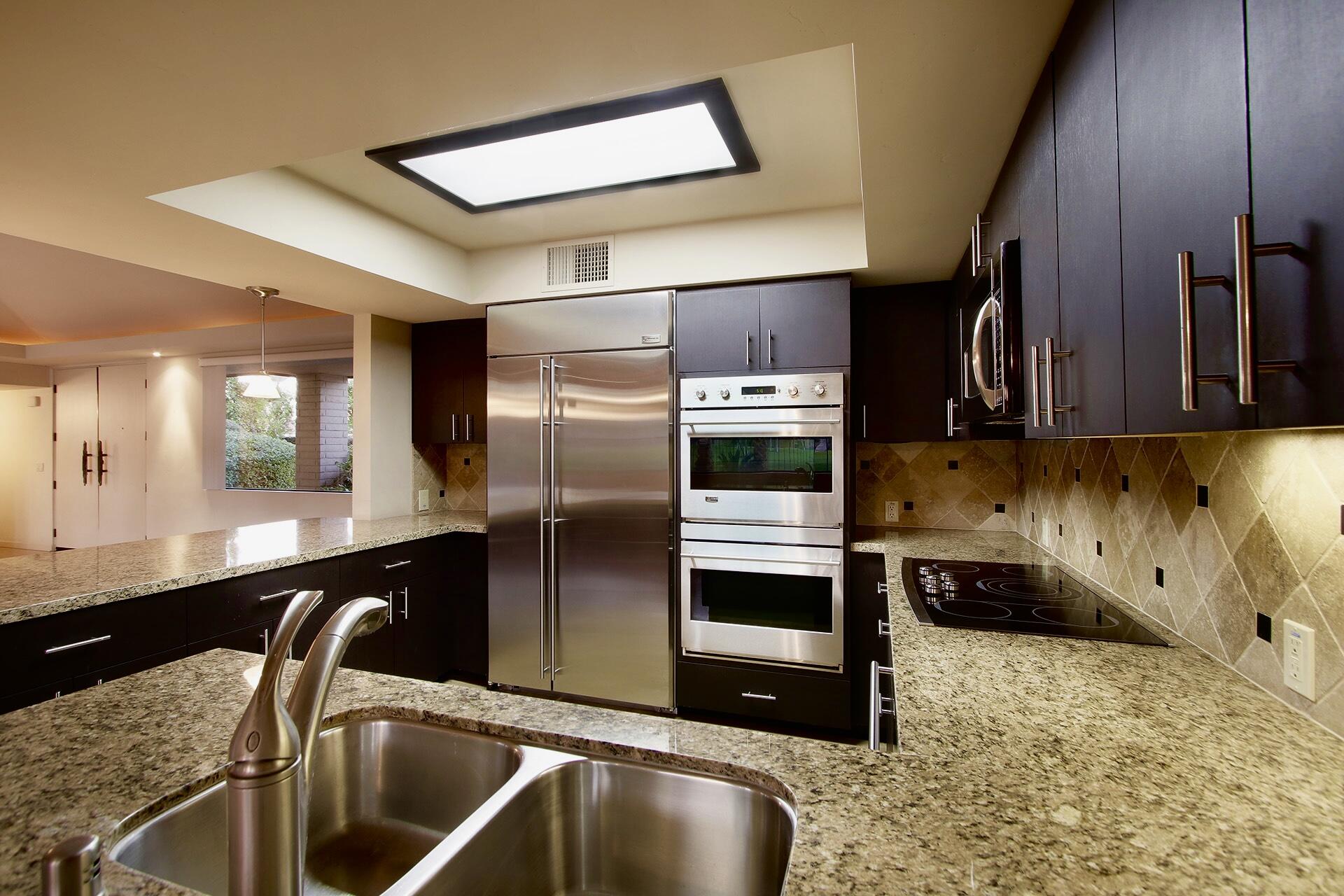 40281 Sand Dune Road Rancho Mirage, CA 92270 - Photo 19 of 41 a kitchen with stainless steel appliances granite countertop a sink a stove and a refrigerator