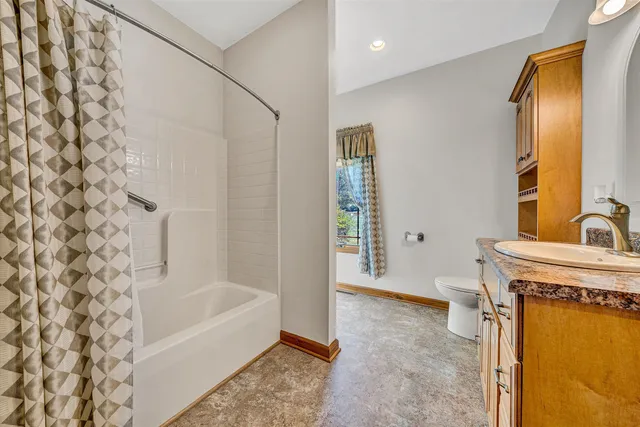 an empty room with windows and ceiling fan