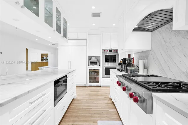 a kitchen with stainless steel appliances granite countertop a stove a sink a dining table and chairs