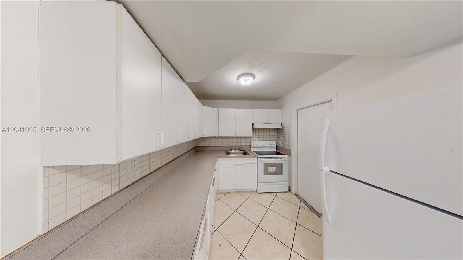 6811 Southwest 16th Street Miami, FL 33144 - Photo 4 of 21 a kitchen with a sink a stove top oven and cabinets