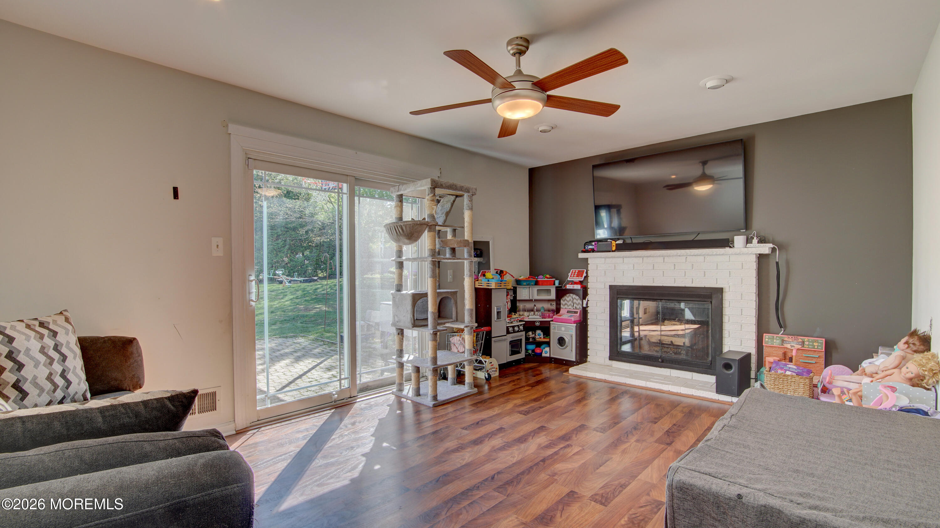 128 Starlight Road Howell, NJ 07731 - Photo 12 of 36 a living room with furniture a fireplace and a flat screen tv