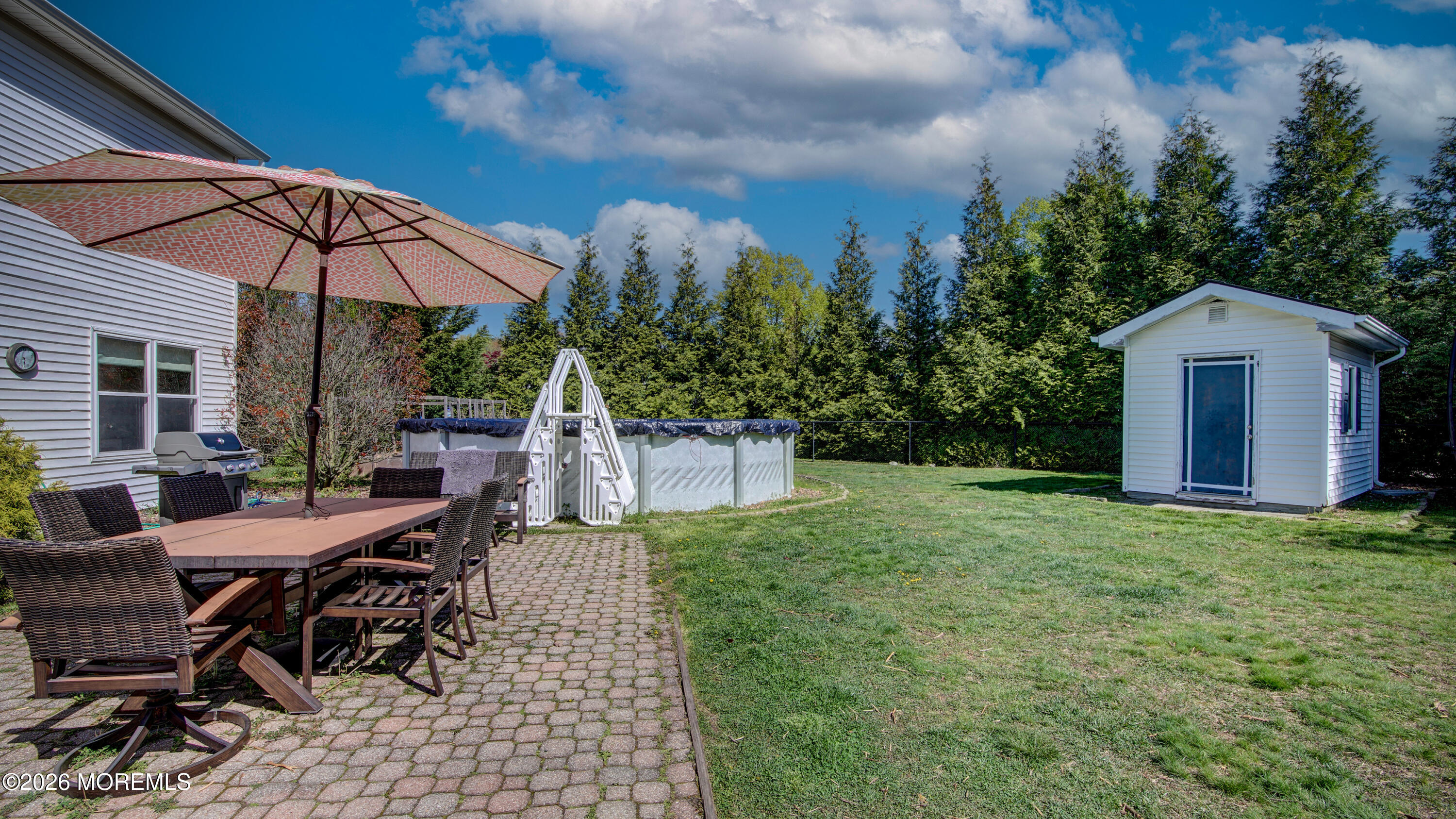 128 Starlight Road Howell, NJ 07731 - Photo 25 of 36 a view of a patio with table and chairs under an umbrella