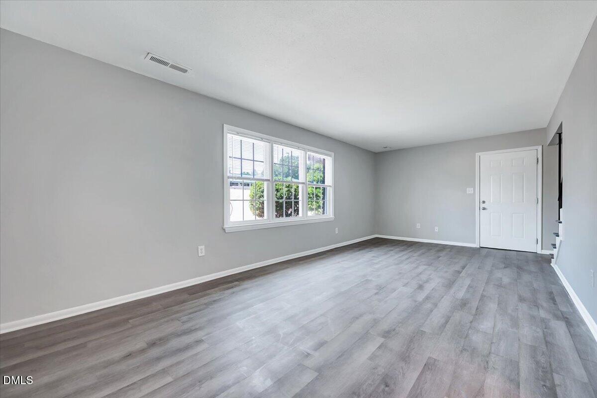 3408 Atlantic Avenue Raleigh, NC 27604 - Photo 26 of 48 an empty room with wooden floor and windows