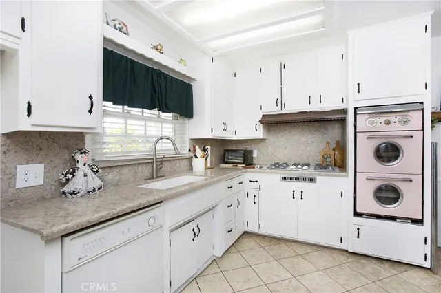 a kitchen with granite countertop white cabinets and white appliances