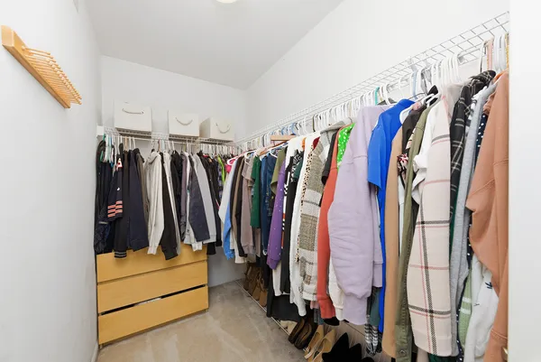 a view of walk in closet with clothes and shoes