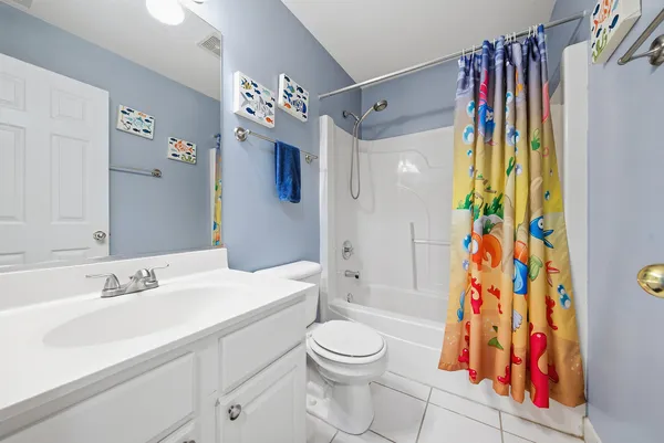 a bathroom with a sink a toilet and shower curtain