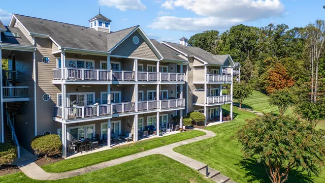 a view of a house with a big yard plants and large trees