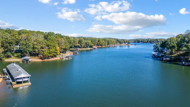 a view of a house with swimming pool and patio with a lake view