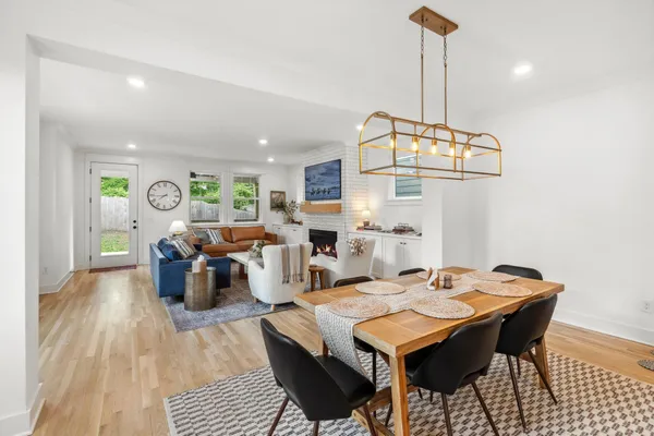 a dining room with furniture a chandelier and wooden floor