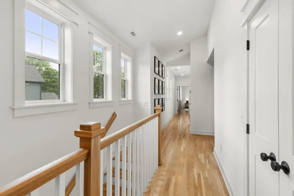 a view of a hallway with wooden floor and staircase