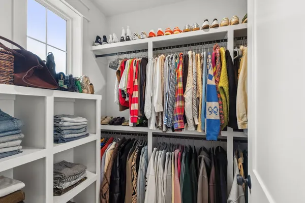 a view of walk in closet with clothes and shoes